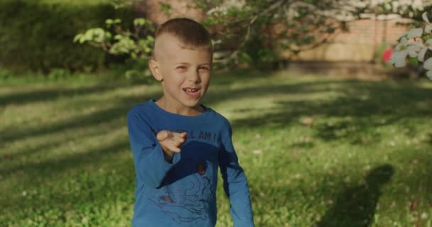 Przystojny chłopczyk pokazujący dłonie gestem pocałunku powietrza - Materiał filmowy, wideo