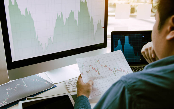 Крупный план руки инвесторы указывают на ноутбук, который имеет инвестиционную информацию фондовые рынки и партнеры делают заметки и анализируют данные о производительности
. - Фото, изображение