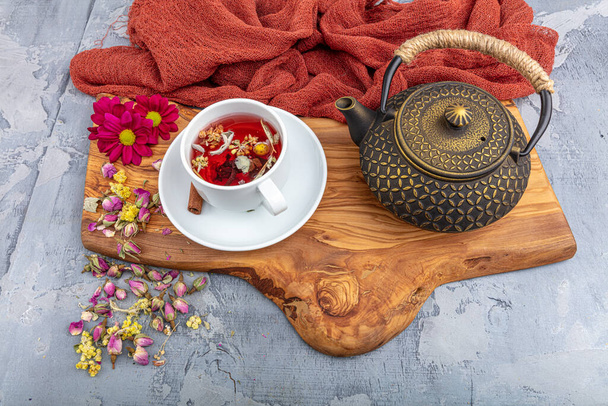 Травяной чай с цветами розы в чугунный чайник. Азиатский стиль
. - Фото, изображение