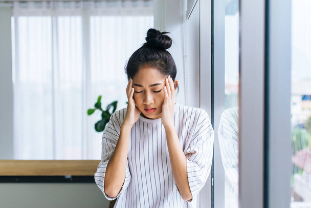 Asian woman having a headache in bedroom,Women suffering from migraine at home - Фото, зображення