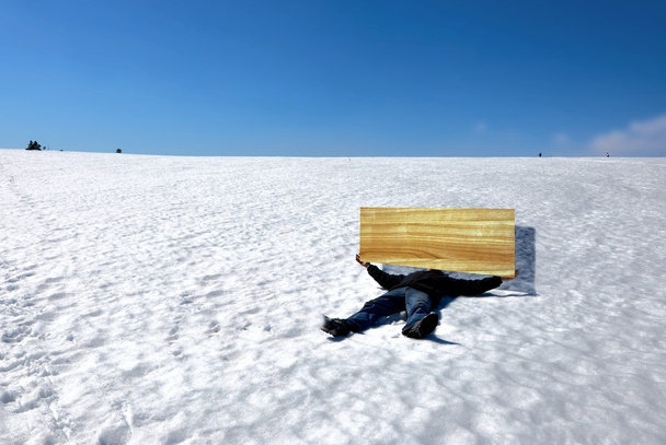 kar kış aylarında kurulu ile yatan adam - Fotoğraf, Görsel