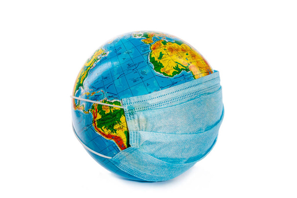 Globe of planet Earth in a medical mask, protection against coronovirus COVID-19 - Fotoğraf, Görsel