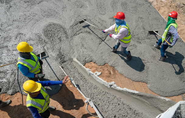 Rakennustyöntekijä kaataa betonia rakennustyömaalle - Valokuva, kuva