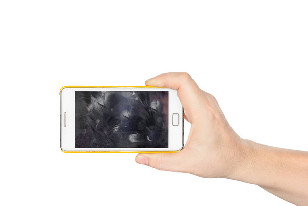 Mano sosteniendo teléfono inteligente blanco con pantalla sucia huella dactilar
 - Foto, Imagen