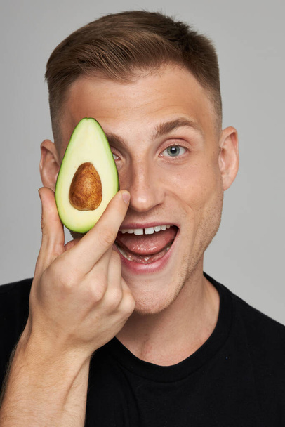 Avocado Facial Treatment. Skin Care With Natural Vitamins. Male Model Holds Fresh Fruit Near Face And Screams. - Foto, immagini