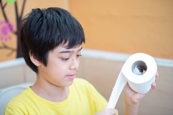 Little boy teen use tissue paper clean in toilet - Zdjęcie, obraz