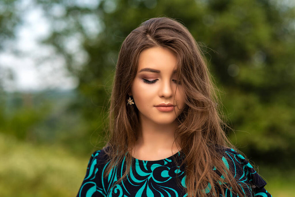 Closeup portrait of pretty girl with attractive makeup on green background. - Foto, Bild