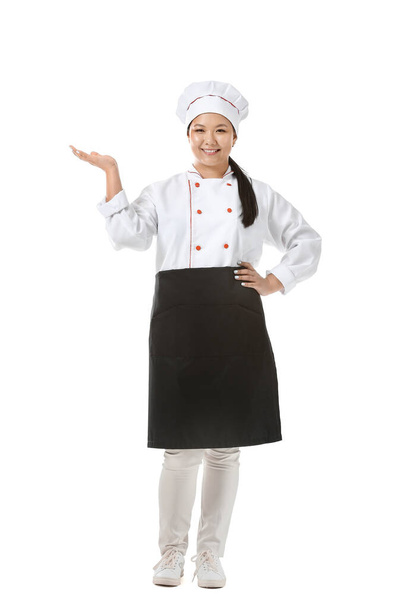 Чудовий азійський шеф-кухар показує щось на білому фоні. - Фото, зображення