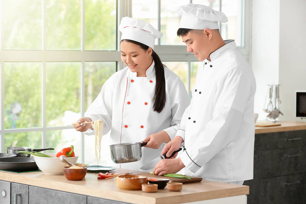 Azji kucharze gotowanie razem w kuchni - Zdjęcie, obraz