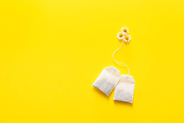 Chamomile tea in bags on color background - Фото, изображение