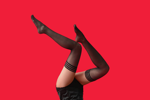 Legs of beautiful young woman in stockings on color background - Foto, imagen