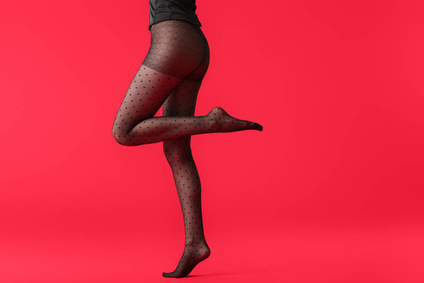 Las piernas de la hermosa mujer joven en medias sobre fondo de color
 - Foto, Imagen