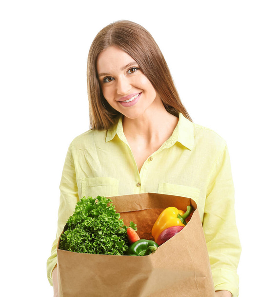 Mladá žena drží tašku s jídlem na bílém pozadí - Fotografie, Obrázek
