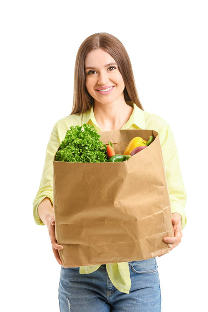 Beyaz arka planda yiyecek dolu çanta taşıyan genç bir kadın. - Fotoğraf, Görsel