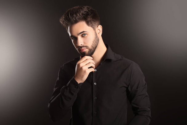 Handsome man with stylish hairdo on dark background - Photo, Image