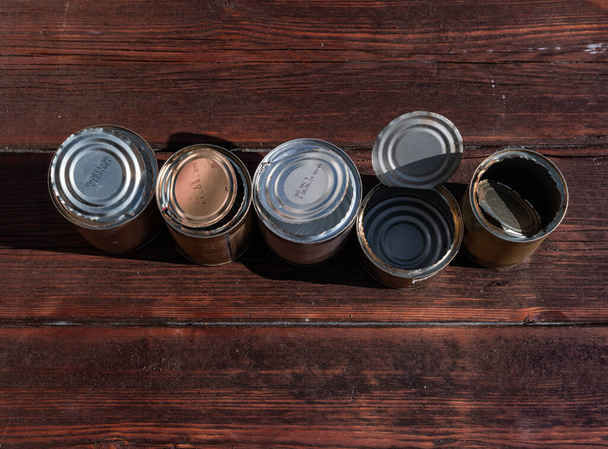 Velhas latas vazias enferrujadas em um fundo de madeira texturizado escuro
 - Foto, Imagem