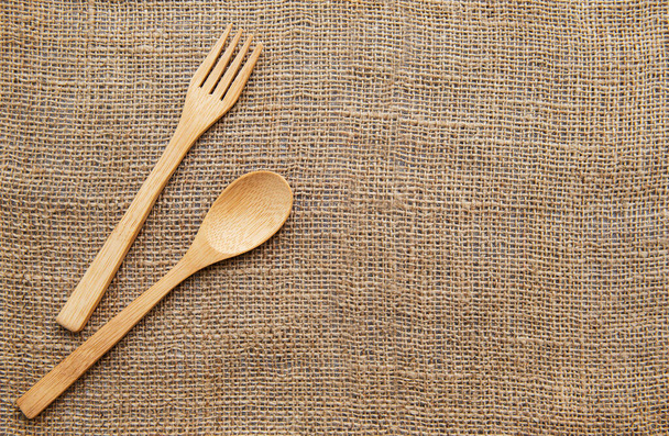 Wooden spoon and  fork on sackcloth backgrounds. Top view - Foto, Bild