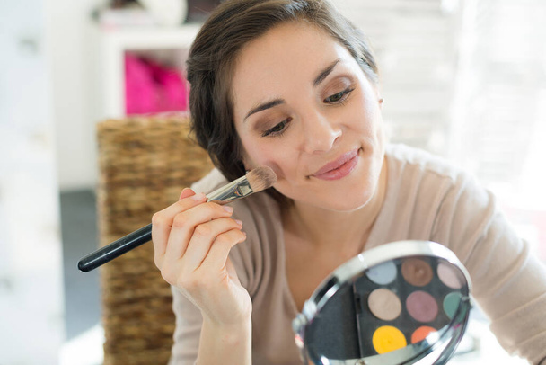 woman putting make up on her face - Fotó, kép