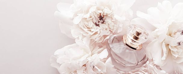 Fragancia botella como producto de perfume de lujo en el fondo de flores de peonía, anuncio de perfusión y marca de belleza
 - Foto, Imagen