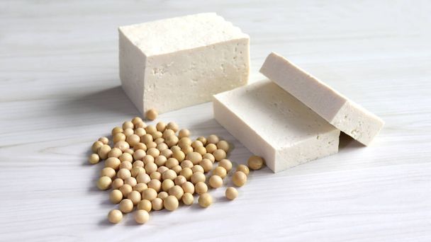 Gelbe Bohnen und weißer Tofu im weichen Holzhintergrund. - Foto, Bild