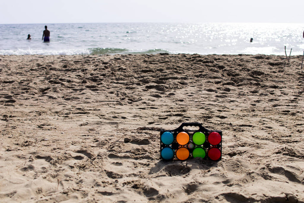 Набор красочных чаш для пляжной игры с морем на заднем плане
 - Фото, изображение