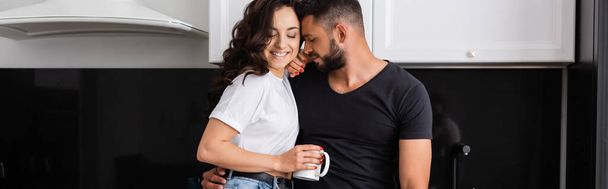 plan panoramique de l'homme heureux près fille souriante tenant tasse de café - Photo, image