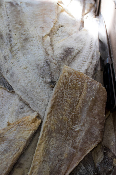 rebanadas de bacalao seco salado para poner nto agua para cocinar. Productos de temporada de la tradición italiana vendidos al mercado
 - Foto, Imagen