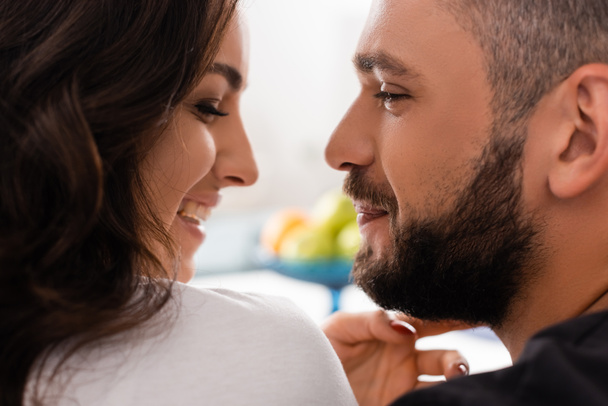 side view of smiling couple looking at each other at home - Photo, Image