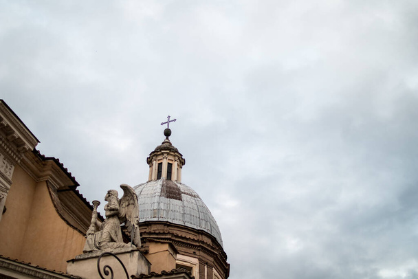 dome with angel on a baroque church in rome with a cloudy sky background - Foto, Bild