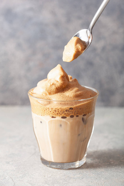 ガラスの中のダルゴナコーヒー。トレンディーなインスタントコーヒーは砂糖とお湯でホイップ - 写真・画像