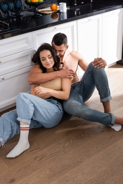 bearded boyfriend and happy girlfriend sitting on floor  - Фото, зображення