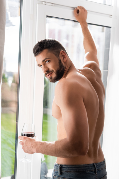 muscular and bearded man holding glass of red wine  - Photo, Image
