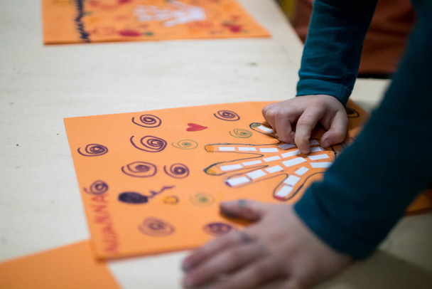 Wissenschaftliche Tätigkeit für Kinder, Zeichnung und Collage der Handknochen. Auf einem orangefarbenen Zettel wurde eine Hand gezeichnet und mit Filzstiften gefärbt. Kreative Aktivitäten für den STEAM-Unterricht - Foto, Bild
