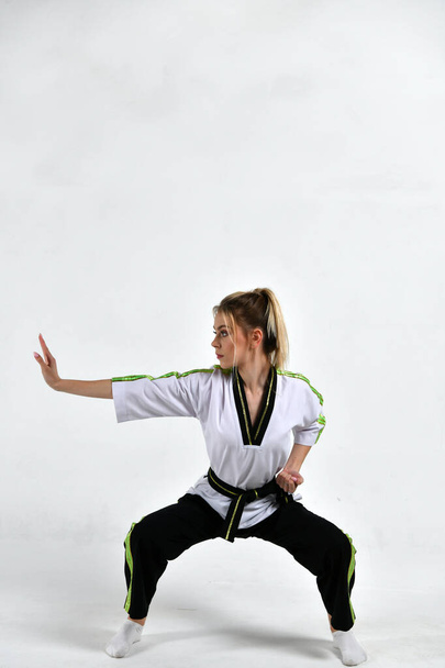kaunis tyttö taistelija mustavalkoinen kimono tekee harjoituksia tyyliin taistelulajien - Valokuva, kuva