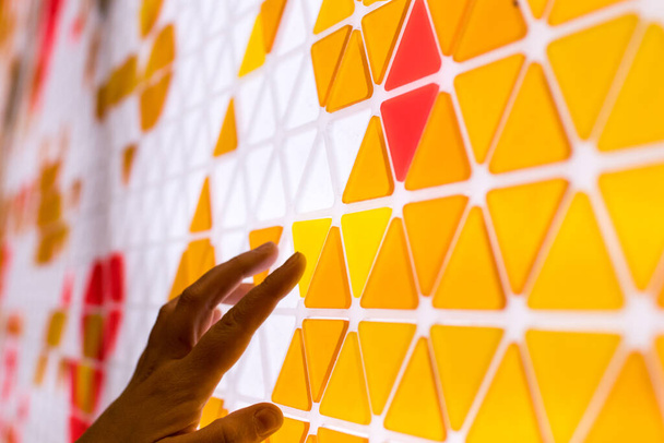 теселяція площини з жовтими, помаранчевими та червоними трикутниками на білому тлі. математична і художня гра, щоб покрити поверхню геометричними фігурами. діти грають в математичні ігри з рукою
 - Фото, зображення