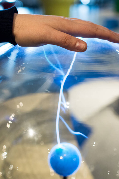 Electric sphere produce plasma with blue sparks and bolt. Science education experiment with electricity and plasma ball. Science project circuit and electricity for kids in stem activity - Photo, Image