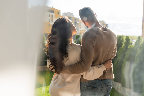 vista trasera del hombre de pie y abrazando novia fuera
  - Foto, Imagen