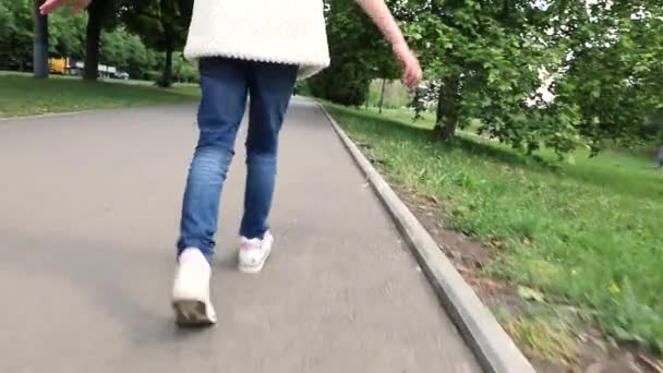 The girl runs through the park. view from a back - Video