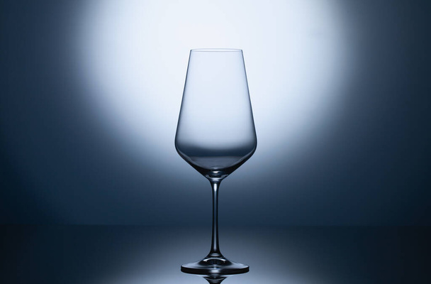 Empty wine glass on a blue clean gradient background. Empty drinking transparent wine glass - Foto, imagen