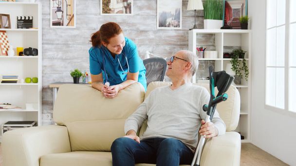 Uomo in pensione in casa di cura a parlare con un'infermiera
 - Foto, immagini