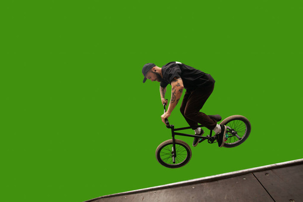 BMX ratsastaja eristetty vihreällä näytöllä. - Valokuva, kuva
