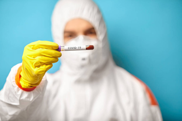 Express test on coronavirus. Scientist in protective coverall hold blood test. - Фото, изображение