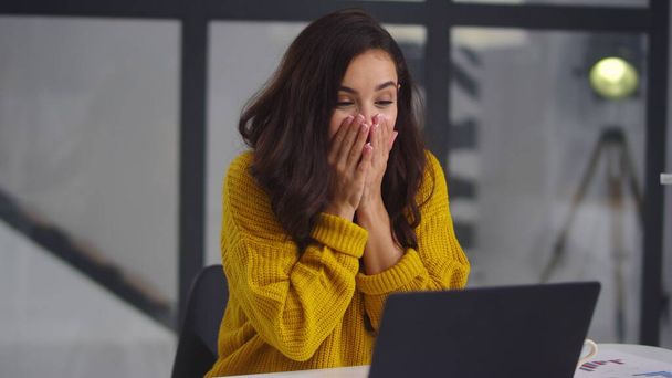 Surprised woman looking computer screen. Cheerful girl chatting on laptop - Fotó, kép