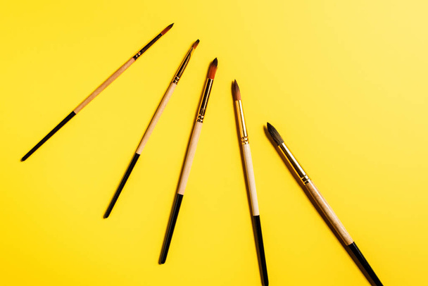 Top view of paintbrushes on yellow background with copy space - Photo, Image