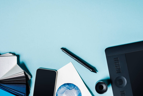 Вид сверху смартфона, цветные часы с графической таблицей и акварельным рисунком на синем фоне
 - Фото, изображение