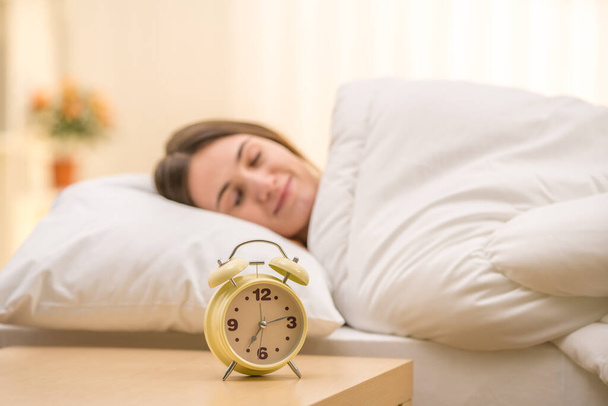 Klasyczny zegar na tle śpiącej kobiety - Zdjęcie, obraz