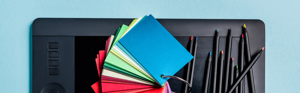 Панорамные образцы цветов, графические планшеты и цветные карандаши на синем фоне
 - Фото, изображение