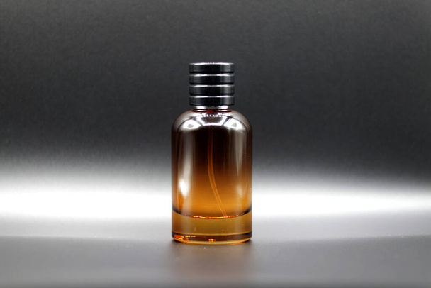 Frasco de perfume de vidro de cor vermelha sem etiqueta ou adesivo em um fundo preto
 - Foto, Imagem