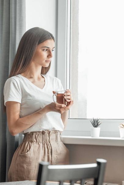 Красива жінка п'є ранковий чай за вікном. Виклик нового дня. Копіювати простір
 - Фото, зображення