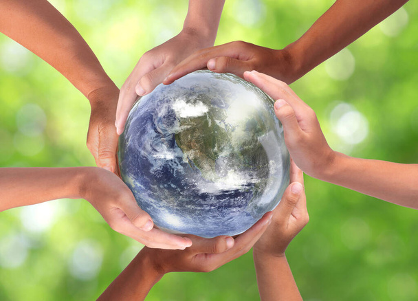 Símbolo conceptual de manos humanas multirraciales que rodean el globo terráqueo. Unidad, paz mundial, concepto de humanidad. Día mundial del medio ambiente
 - Foto, Imagen